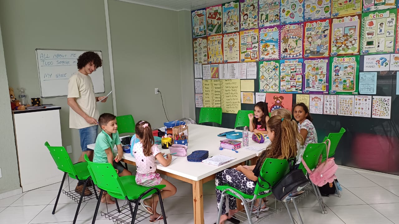 Turma de crianças em aula de inglês na Avantis, com professor e sala decorada