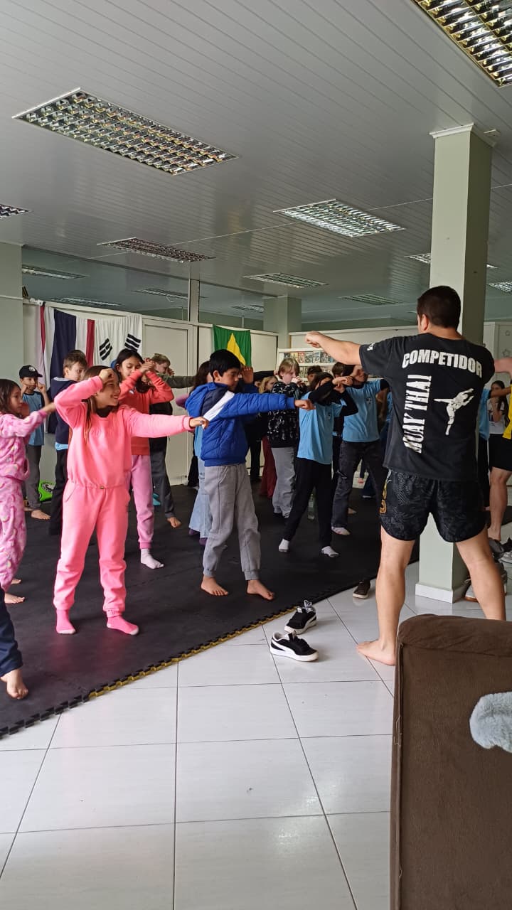 Turma de crianças treinando Muay Thai no tatame da Avantis